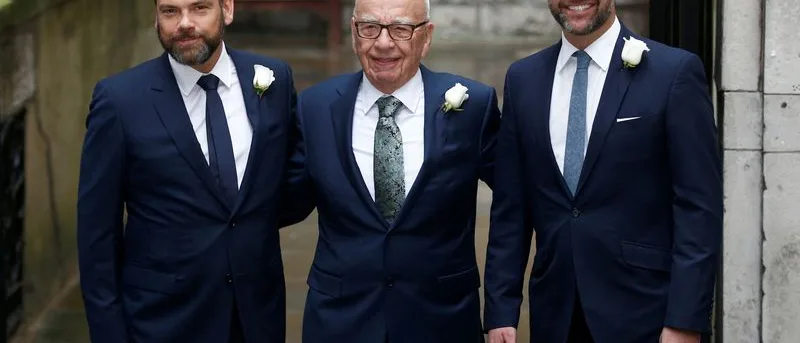 Rupert Murdoch walking in a dark suit, representing the high-stakes family succession battle over his media empire